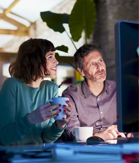 A woman and man at at their computer developing their strategy while working with brandiD