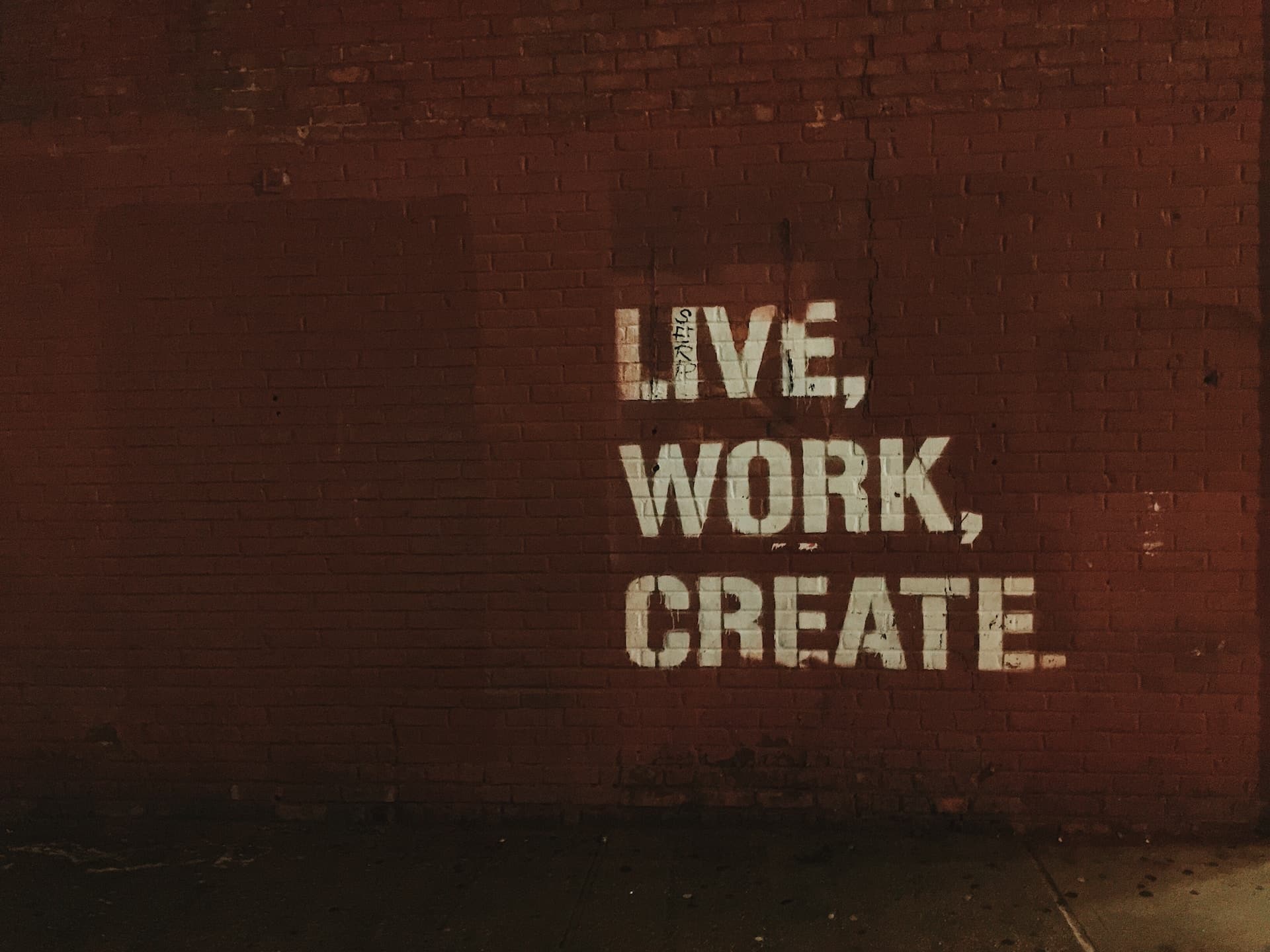 A wall with the words live, work, create written on them