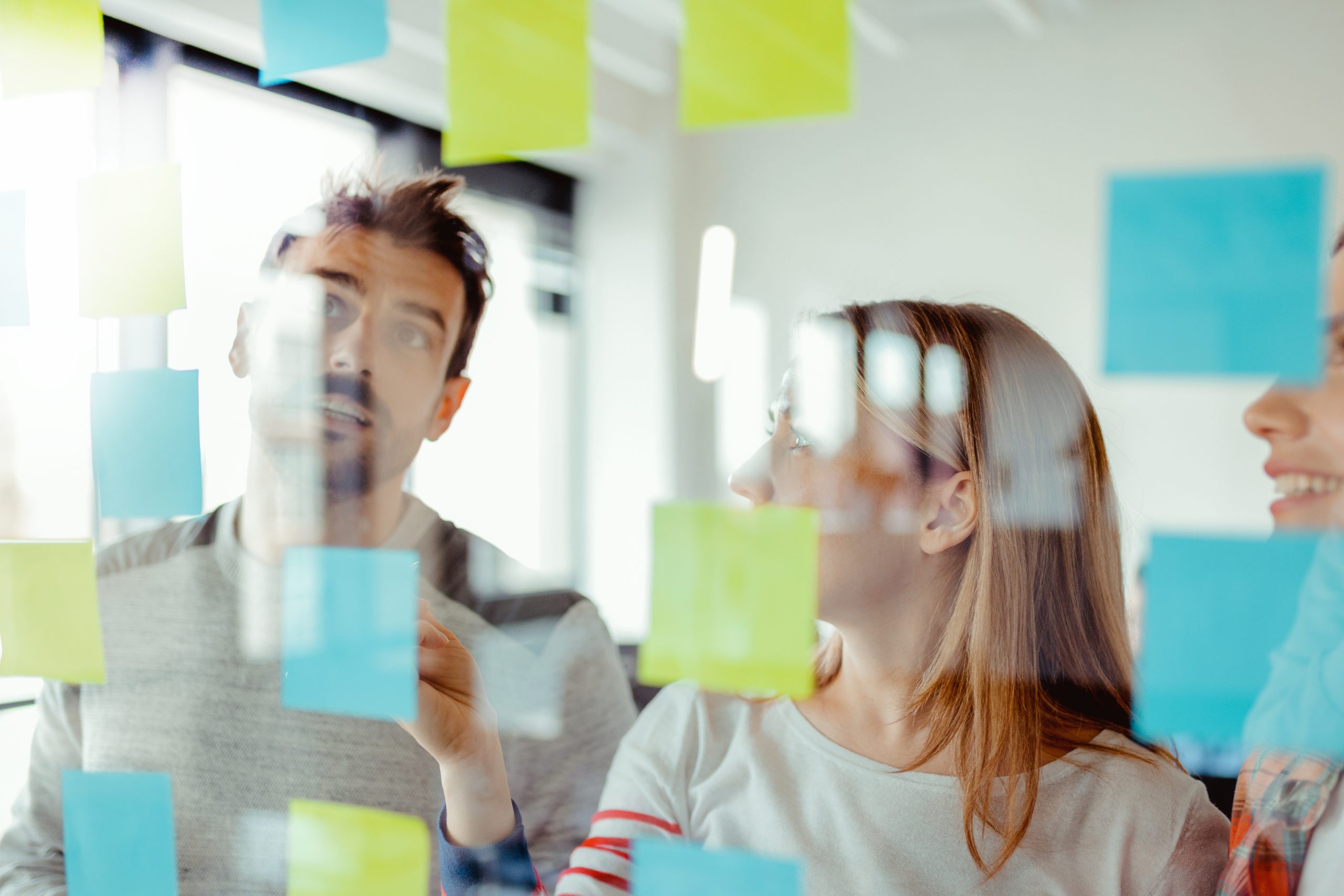 Team reviewing business processes and the cost of business growth using sticky notes